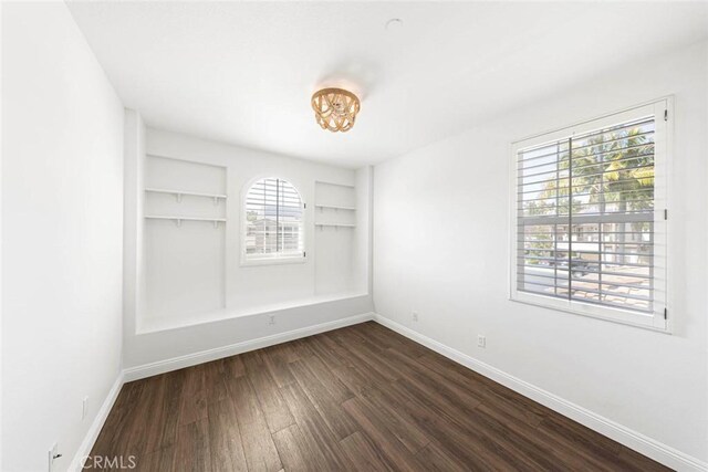 107 Plaza Via Sol, San Clemente, CA 92673 - empty room with dark wood finished floors, baseboards, a chandelier, and built in shelves