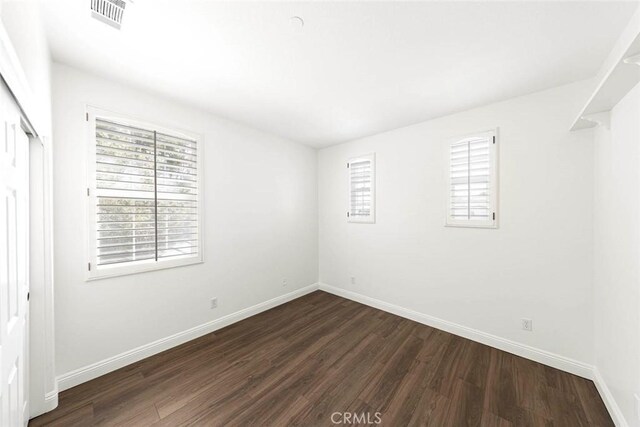 107 Plaza Via Sol, San Clemente, CA 92673 - unfurnished bedroom with dark wood-style floors, multiple windows, and baseboards