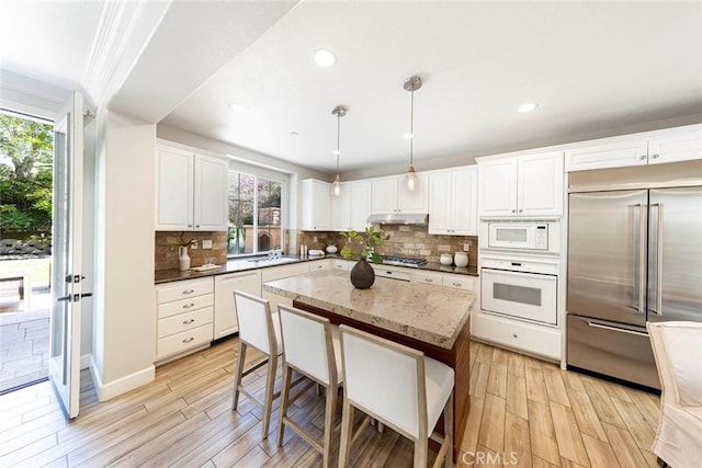 107 Plaza Via Sol, San Clemente, CA 92673 - kitchen featuring built in appliances, under cabinet range hood, light wood-style floors, backsplash, and recessed lighting