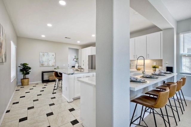 26149 Manzanita St, Murrieta, CA 92563 - kitchen featuring a kitchen bar, recessed lighting, white cabinetry, baseboards, and backsplash
