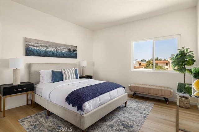 bedroom with wood finished floors and baseboards