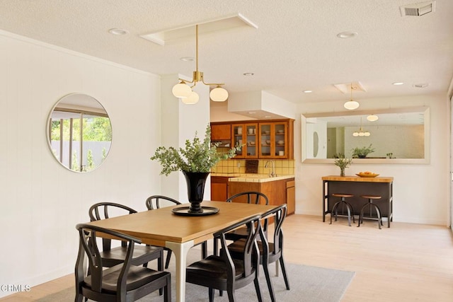 756 Linda Vista Ave, Pasadena, CA 91103 - dining space with a textured ceiling, baseboards, light wood-type flooring, and ornamental molding