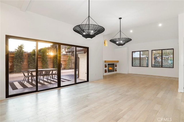 5633 E Deborah St, Long Beach, CA 90815 - unfurnished living room featuring healthy amount of natural light, light wood-type flooring, recessed lighting, vaulted ceiling, and a warm lit fireplace
