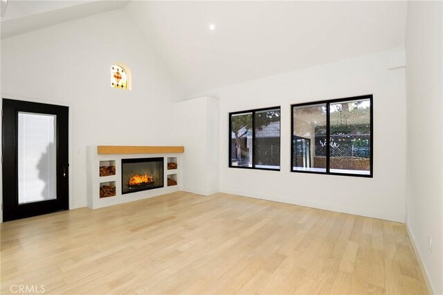 5633 E Deborah St, Long Beach, CA 90815 - unfurnished living room with high vaulted ceiling, wood finished floors, and a glass covered fireplace