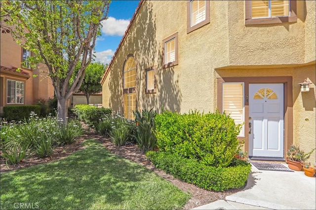 48 Via Athena, Aliso Viejo, CA 92656 - doorway to property with stucco siding and a lawn