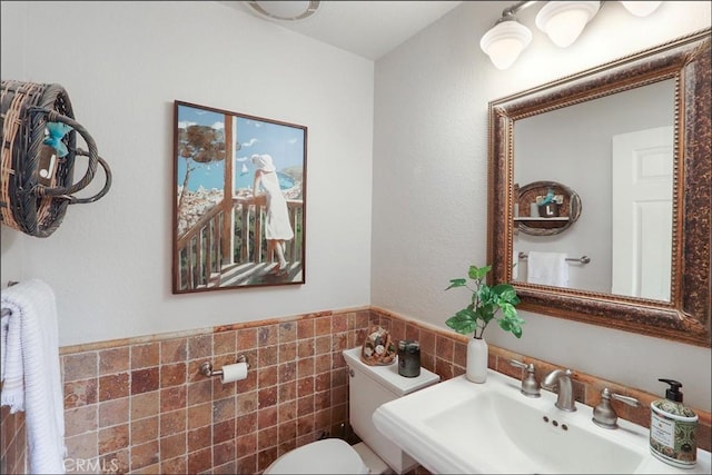 48 Via Athena, Aliso Viejo, CA 92656 - half bathroom featuring a sink, toilet, tile walls, and a wainscoted wall