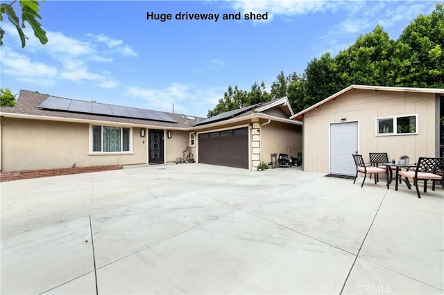10500 Jordan Ave, Chatsworth, CA 91311 - ranch-style home featuring an attached garage, solar panels, concrete driveway, and stucco siding