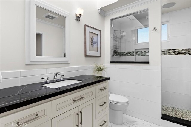 3080 Studio Dr, Cayucos, CA 93430 - full bath featuring ornamental molding, toilet, a walk in shower, marble look tile flooring, and tile walls