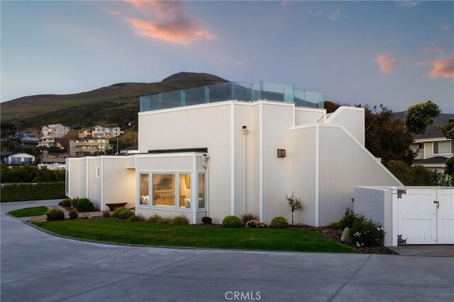 3080 Studio Dr, Cayucos, CA 93430 - view of front of house featuring a gate, a mountain view, and a lawn