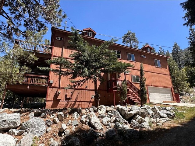 9345 Conifer Dr, Forest Falls, CA 92339 - view of front of home featuring stairs, an attached garage, and a wooden deck