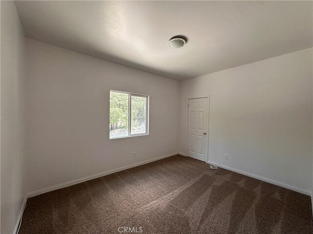 9345 Conifer Dr, Forest Falls, CA 92339 - spare room with dark carpet and baseboards