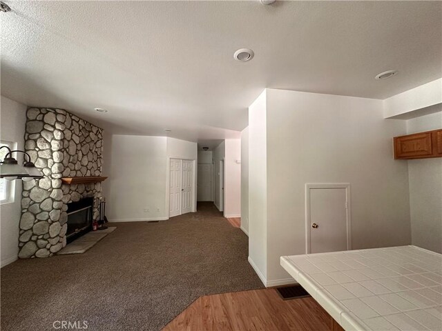 9345 Conifer Dr, Forest Falls, CA 92339 - unfurnished living room featuring wood finished floors, a fireplace, and a textured ceiling