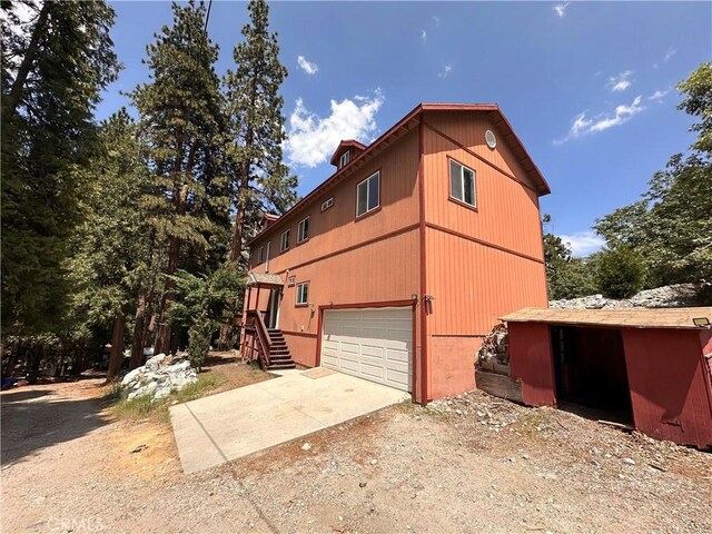 9345 Conifer Dr, Forest Falls, CA 92339 - view of side of property with concrete driveway, an attached garage, and stairs
