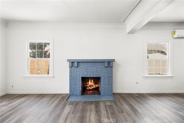 747 W 9th St, San Bernardino, CA 92410 - unfurnished living room featuring a wall mounted AC, wood finished floors, a fireplace with flush hearth, and healthy amount of natural light