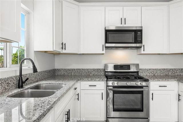 747 W 9th St, San Bernardino, CA 92410 - kitchen featuring appliances with stainless steel finishes, a sink, white cabinets, and light stone countertops