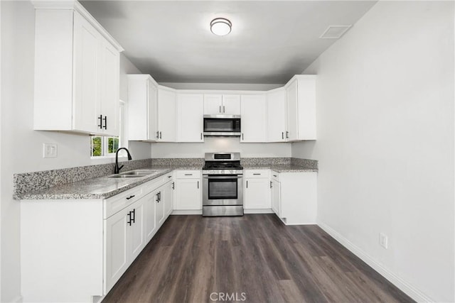 747 W 9th St, San Bernardino, CA 92410 - kitchen featuring appliances with stainless steel finishes, a sink, dark wood-type flooring, light stone counters, and white cabinetry