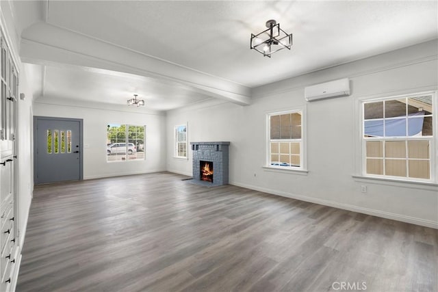 747 W 9th St, San Bernardino, CA 92410 - unfurnished living room with an AC wall unit, wood finished floors, and baseboards