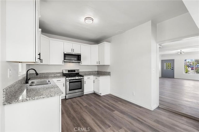 747 W 9th St, San Bernardino, CA 92410 - kitchen featuring stainless steel appliances, a sink, dark wood finished floors, light stone counters, and white cabinets