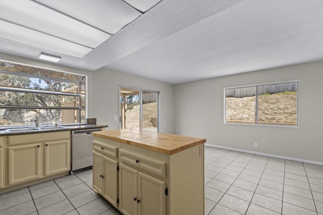 1561 Parkland Way, San Diego, CA 92114 - kitchen with stainless steel dishwasher, light tile patterned flooring, cream cabinets, wood counters, and a center island
