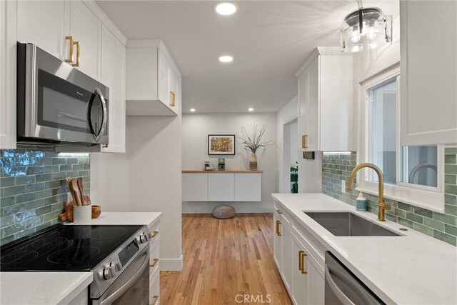 1105 Glenwood Ave, Chico, CA 95926 - kitchen with appliances with stainless steel finishes, a sink, white cabinets, tasteful backsplash, and recessed lighting
