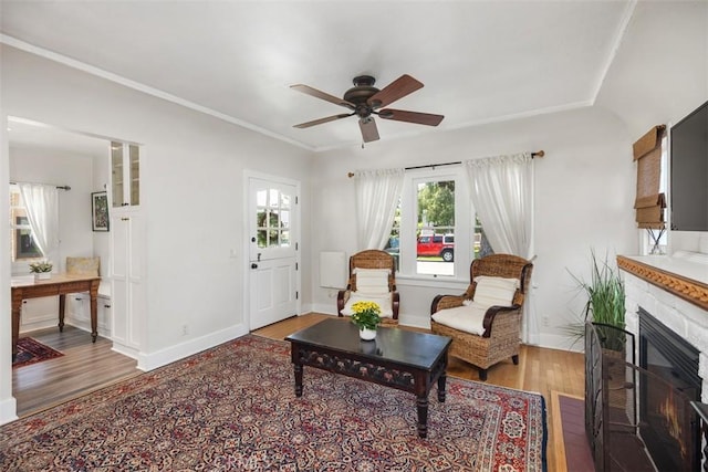 31462 La Matanza St, San Juan Capistrano, CA 92675 - living area with wood finished floors, a ceiling fan, a glass covered fireplace, baseboards, and ornamental molding