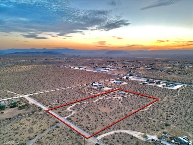 177 Cherokee Trl, Yucca Valley, CA 92284 - aerial overview of property's location featuring a desert landscape, a mountain backdrop, property parcel outlined, and rural landscape