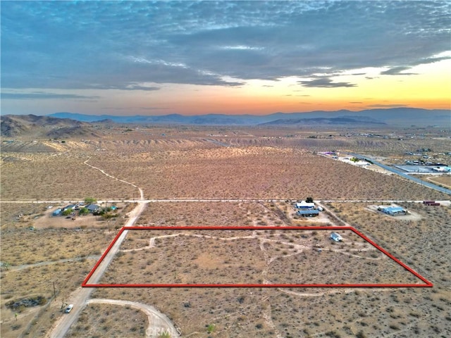 177 Cherokee Trl, Yucca Valley, CA 92284 - aerial view at dusk of a mountain view, property parcel outlined, view of desert landscape, and a rural view