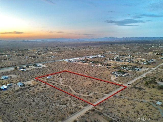177 Cherokee Trl, Yucca Valley, CA 92284 - aerial view at dusk of view of desert landscape, property parcel outlined, a mountain view, and a view of rural / pastoral area