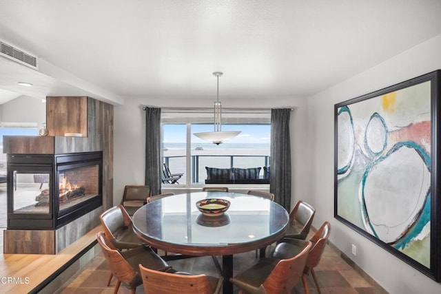 3903 Ocean Dr, Oxnard, CA 93035 - dining area with a multi sided fireplace, baseboards, and stone finish floors