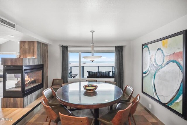 3903 Ocean Dr, Oxnard, CA 93035 - dining space featuring a multi sided fireplace and stone finish flooring