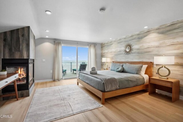 3903 Ocean Dr, Oxnard, CA 93035 - bedroom with access to outside, an accent wall, a large fireplace, light wood-style flooring, and recessed lighting