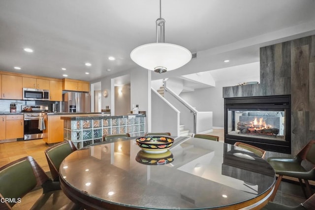 3903 Ocean Dr, Oxnard, CA 93035 - dining room with recessed lighting, stairs, and a multi sided fireplace