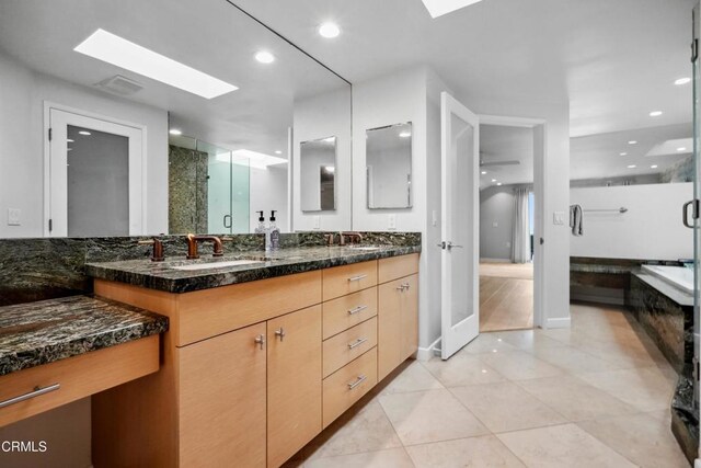 3903 Ocean Dr, Oxnard, CA 93035 - full bath featuring a skylight, double vanity, a shower stall, tile patterned flooring, and a tub