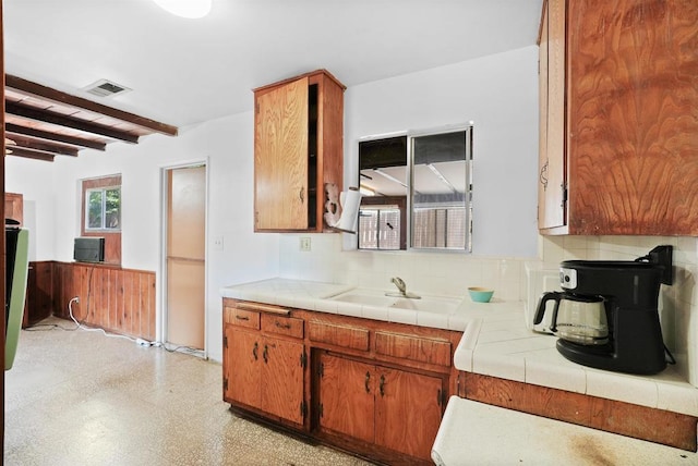 1520 Flanagan St, Pomona, CA 91766 - kitchen with light flooring, beam ceiling, decorative backsplash, a sink, and tile counters