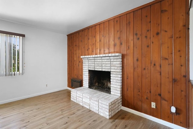 1520 Flanagan St, Pomona, CA 91766 - unfurnished living room featuring a brick fireplace, baseboards, wood finished floors, and wood walls