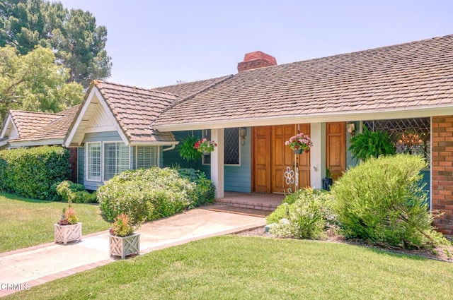 11616 E Las Posas Rd, Camarillo, CA 93012 - view of front of house featuring a chimney, a front lawn, brick siding, and covered porch