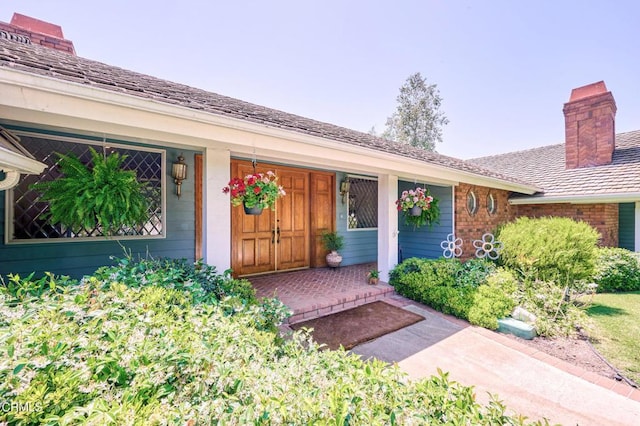 11616 E Las Posas Rd, Camarillo, CA 93012 - view of exterior entry featuring brick siding, covered porch, and a chimney
