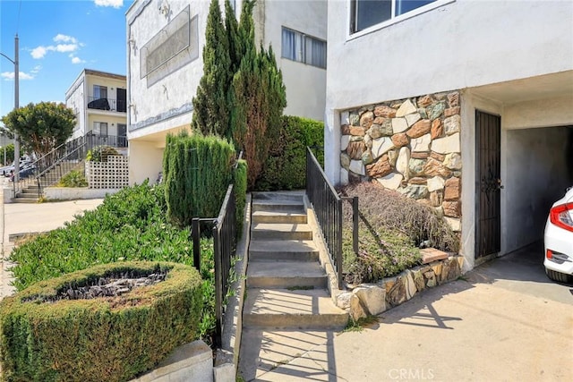 property entrance featuring stucco siding and stone siding