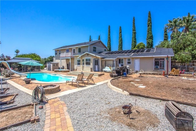 375 E County Line Rd, Calimesa, CA 92320 - back of property with solar panels, a fire pit, a patio area, and a storage unit