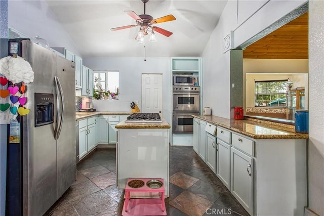 375 E County Line Rd, Calimesa, CA 92320 - kitchen featuring stainless steel appliances, stone tile flooring, vaulted ceiling, a kitchen island, and a ceiling fan