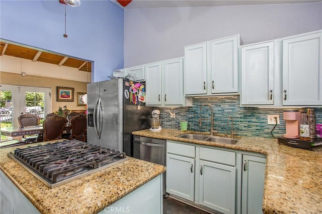 375 E County Line Rd, Calimesa, CA 92320 - kitchen featuring appliances with stainless steel finishes, lofted ceiling, decorative backsplash, french doors, and light stone countertops