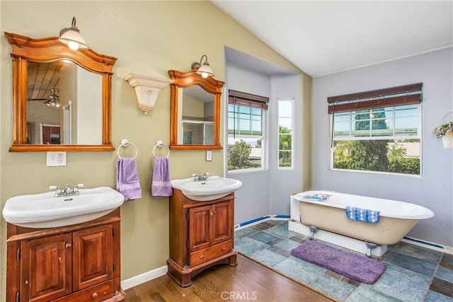 375 E County Line Rd, Calimesa, CA 92320 - bathroom featuring vaulted ceiling, two vanities, a freestanding bath, a shower, and wood finished floors