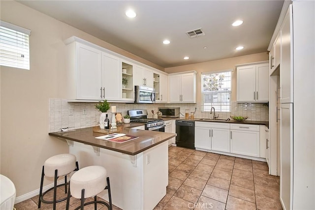 2910 E Via Terrano, Ontario, CA 91764 - kitchen featuring stainless steel appliances, a peninsula, a sink, tasteful backsplash, and dark countertops