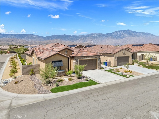 27 Medoc, Rancho Mirage, CA 92270 - mediterranean / spanish house featuring stucco siding, an attached garage, a mountain view, a tile roof, and driveway