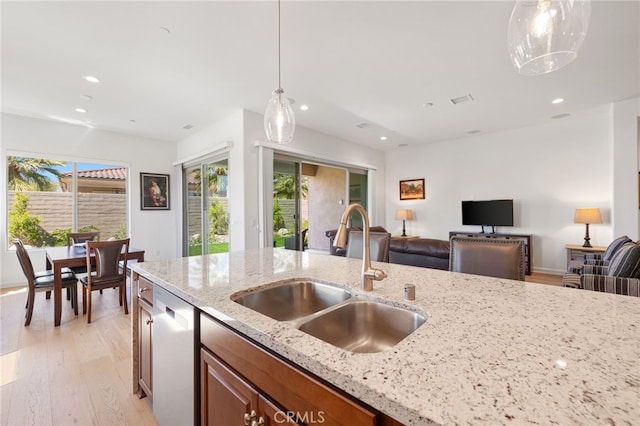 27 Medoc, Rancho Mirage, CA 92270 - kitchen featuring a sink, stainless steel dishwasher, recessed lighting, brown cabinets, and light wood-style floors