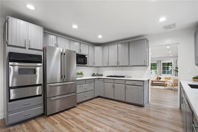 5616 Buffalo Ave, Valley Glen, CA 91401 - kitchen featuring stainless steel appliances, gray cabinetry, a warming drawer, light wood-style flooring, and light countertops