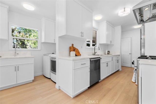 6454 Baird Ave, Reseda, CA 91335 - kitchen featuring washing machine and dryer, stainless steel dishwasher, wall chimney exhaust hood, and light wood-style flooring