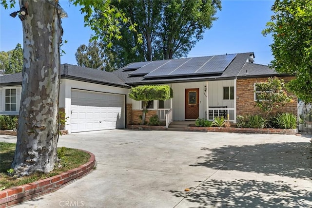 6454 Baird Ave, Reseda, CA 91335 - ranch-style home with a porch, driveway, an attached garage, solar panels, and roof with shingles