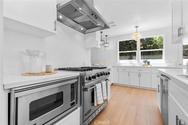 6454 Baird Ave, Reseda, CA 91335 - kitchen featuring wall chimney exhaust hood, stainless steel appliances, light wood-type flooring, and white cabinetry