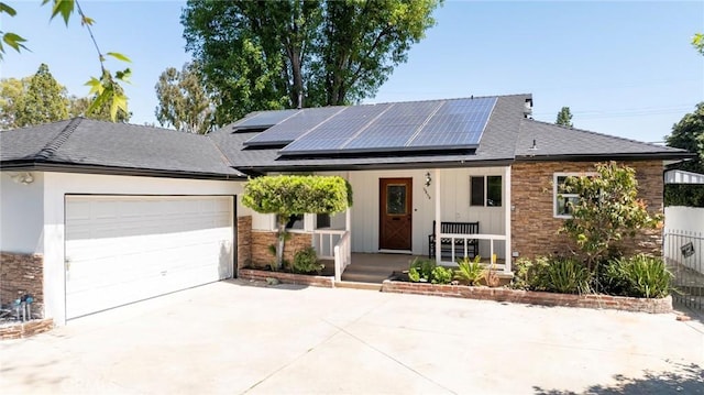 6454 Baird Ave, Reseda, CA 91335 - view of front of house featuring covered porch, driveway, an attached garage, solar panels, and roof with shingles